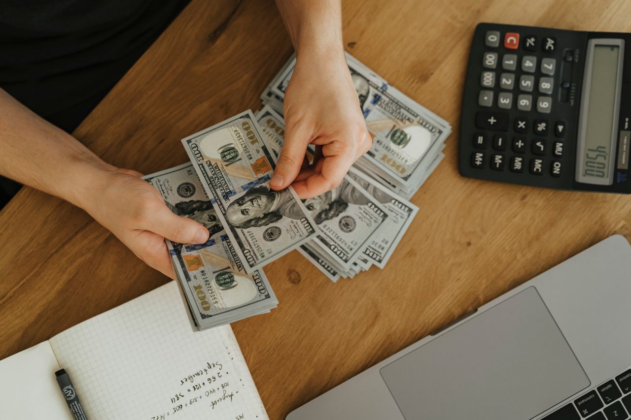 Persona contando dinero, producto de las ventas de curso online con systeme.io