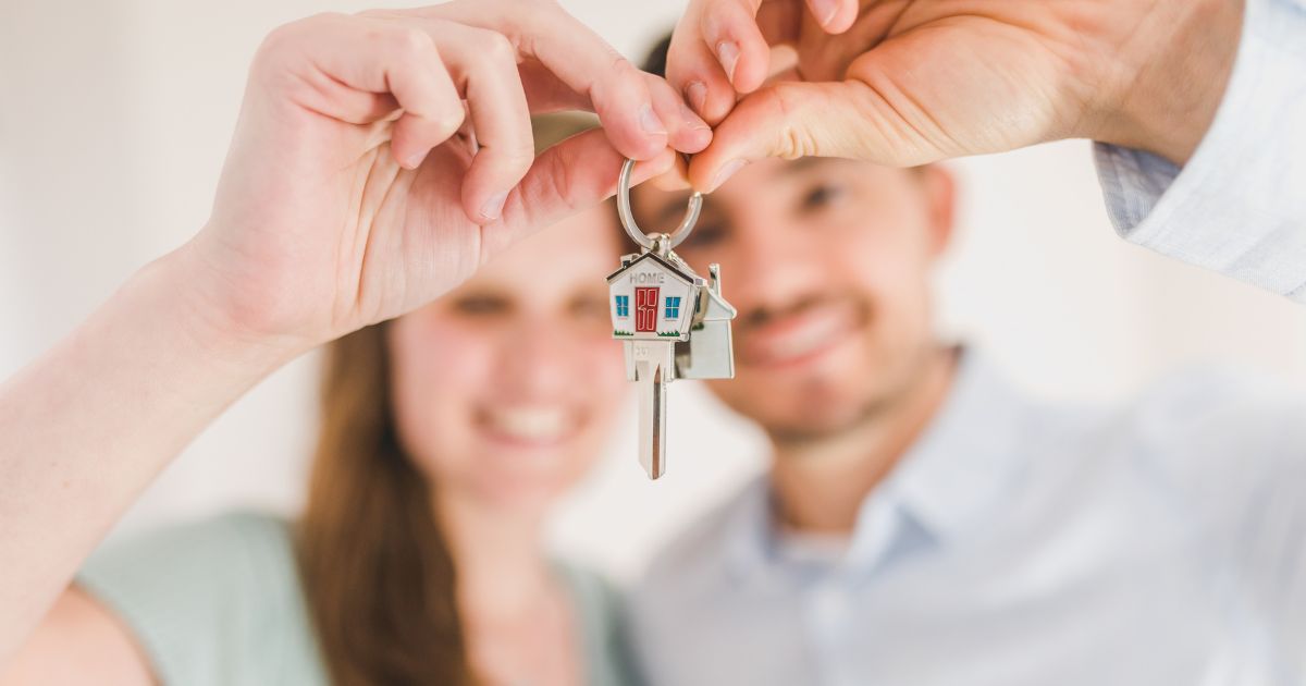 Pareja sosteniendo las llaves de su casa nueva, ejemplo de pasivo según Kiyosaki