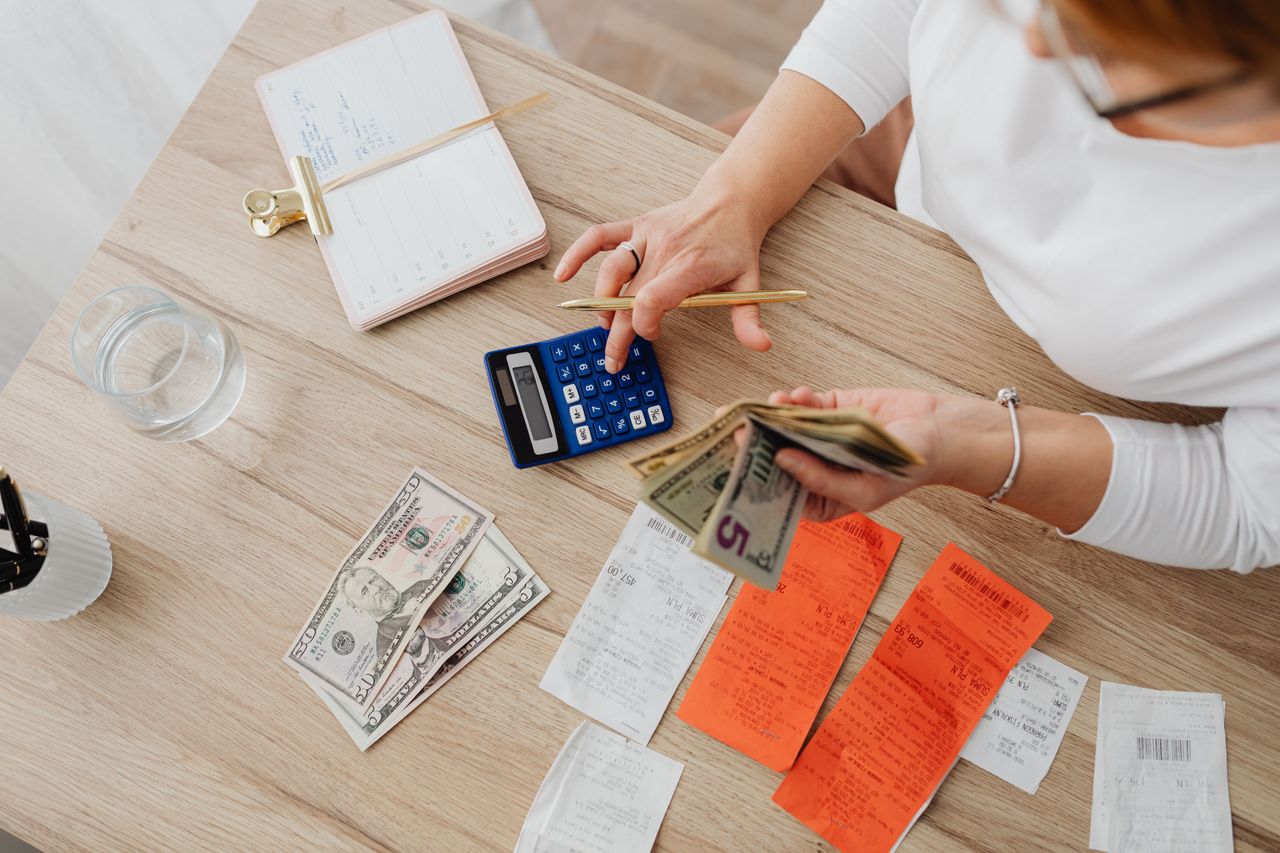 Mujer con una calculadora haciendo cuentas para saber cómo salir de deudas