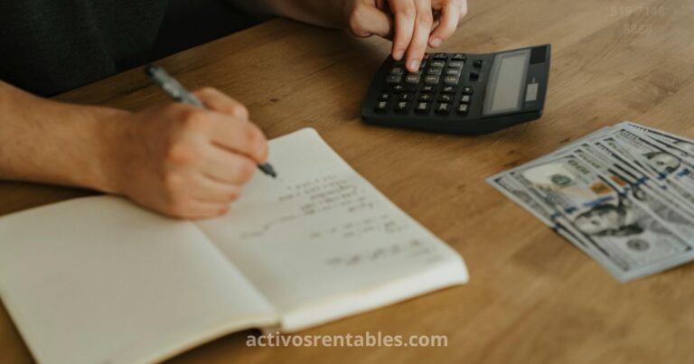 Persona anotando su presupuesto personal a mano en un cuaderno, con calculadora y dinero en efectivo sobre la mesa