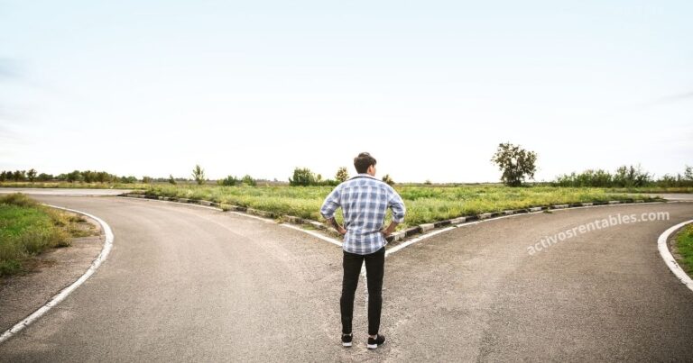 Hombre de espaldas frente a un cruce de caminos, representando la decisión de cambiar de mentalidad de pobre a mentalidad de rico